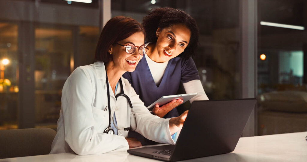 Læge og sygeplejerske tjekker medicinske resultater på computer