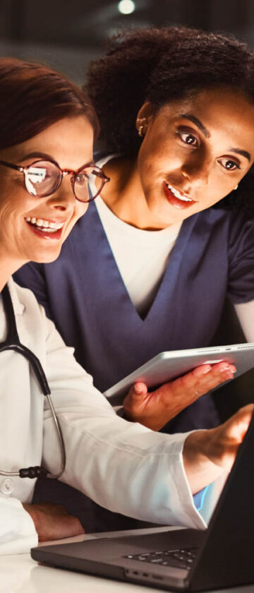 Læge og sygeplejerske tjekker medicinske resultater på computer