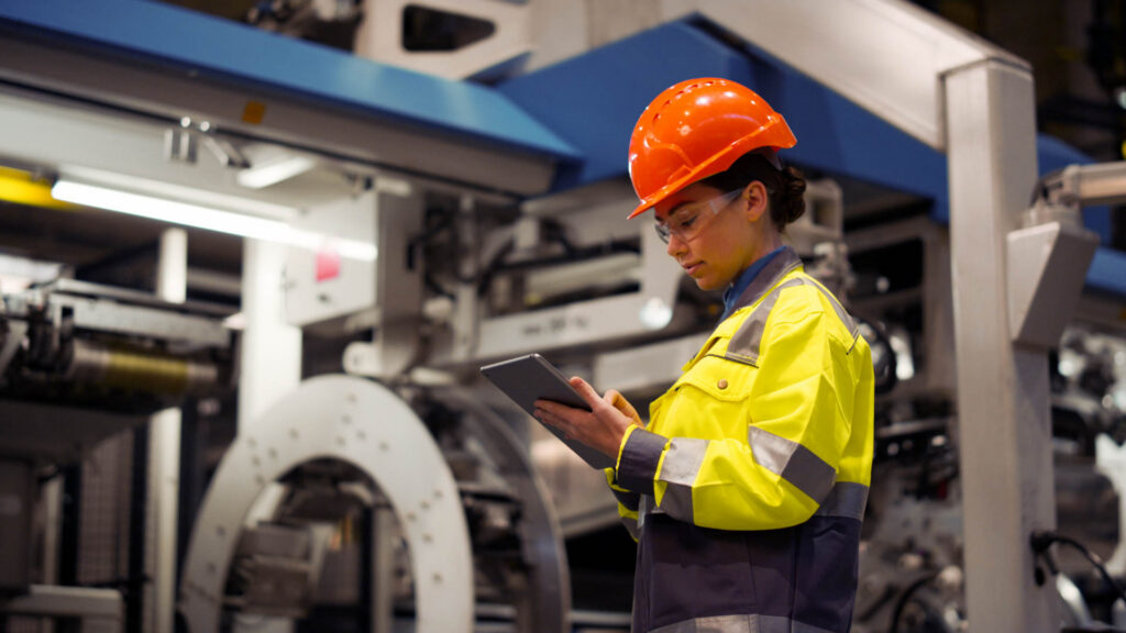 Industrial worker using a tablet in a manufacturing facility