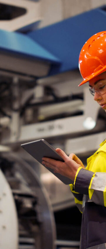 Industrial worker using a tablet in a manufacturing facility