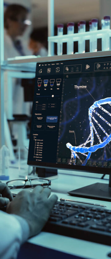 Medical research scientist reviewing genetic data and DNA analysis on a computer screen