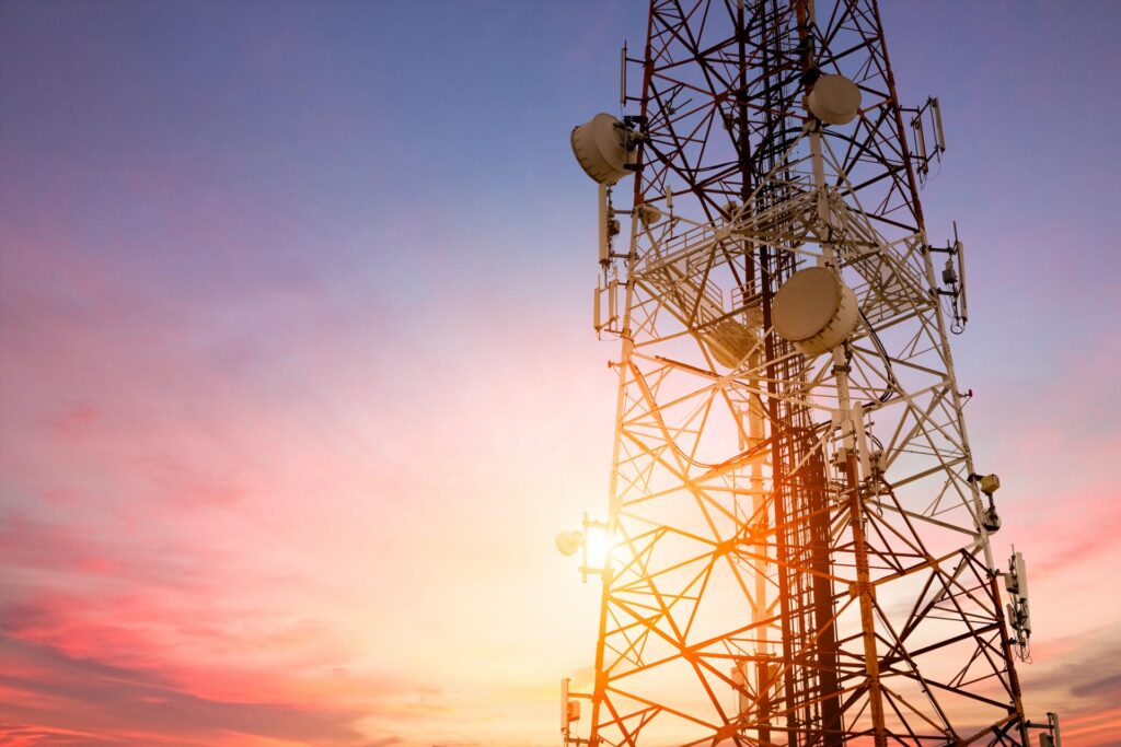 Satellite communication dish transmitting telecom network signals at sunset